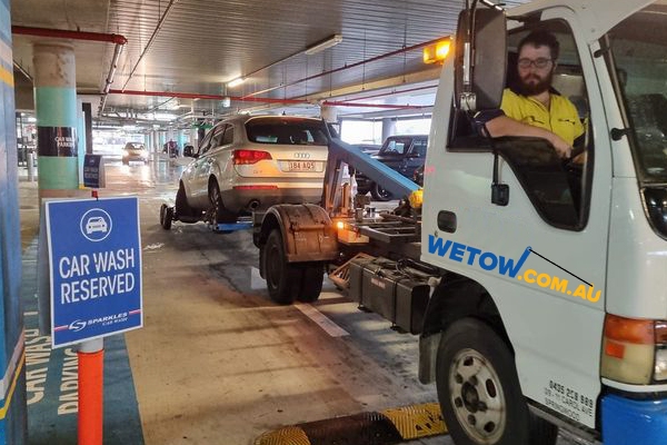 Wheel lift tow truck towing car from a Brisbane underground car park