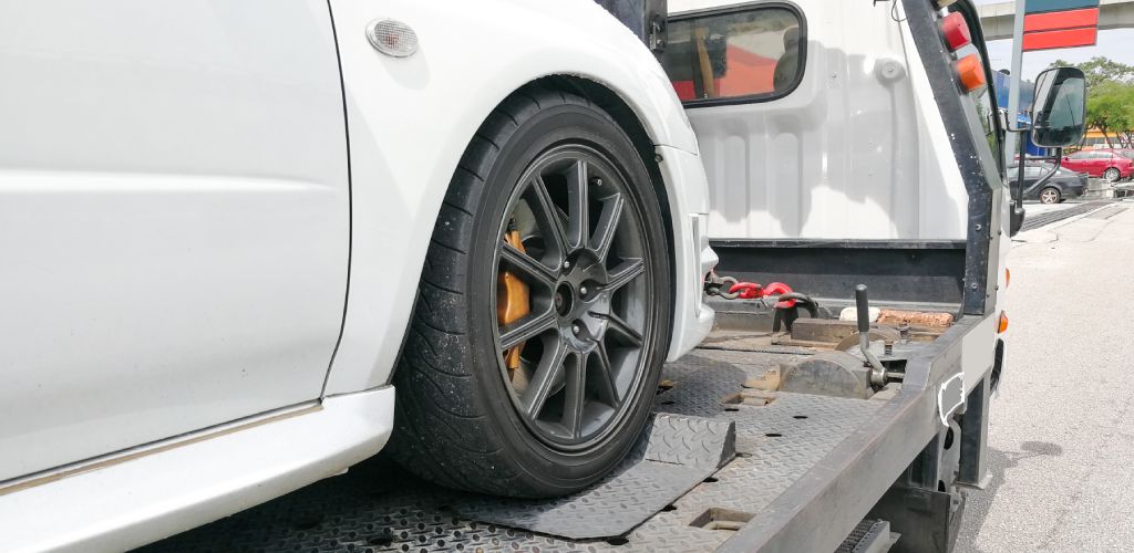 A photo of a car being loaded on the back of a tow truck