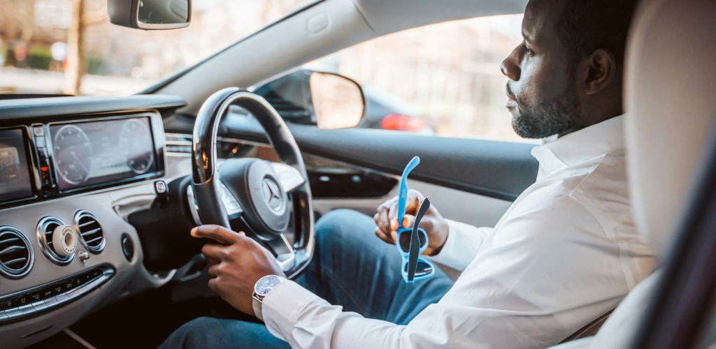 A person sitting in his car in a car park